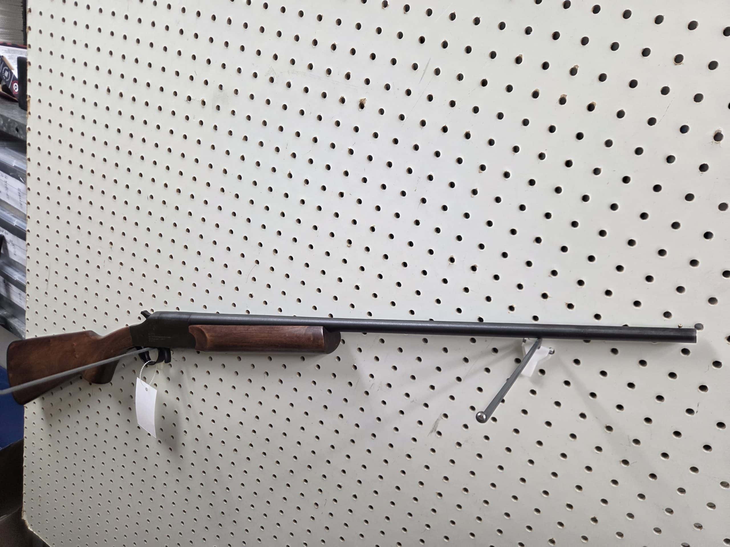 Boito 1 1000014576 single-shot break-action shotgun with a wooden stock on a pegboard display.