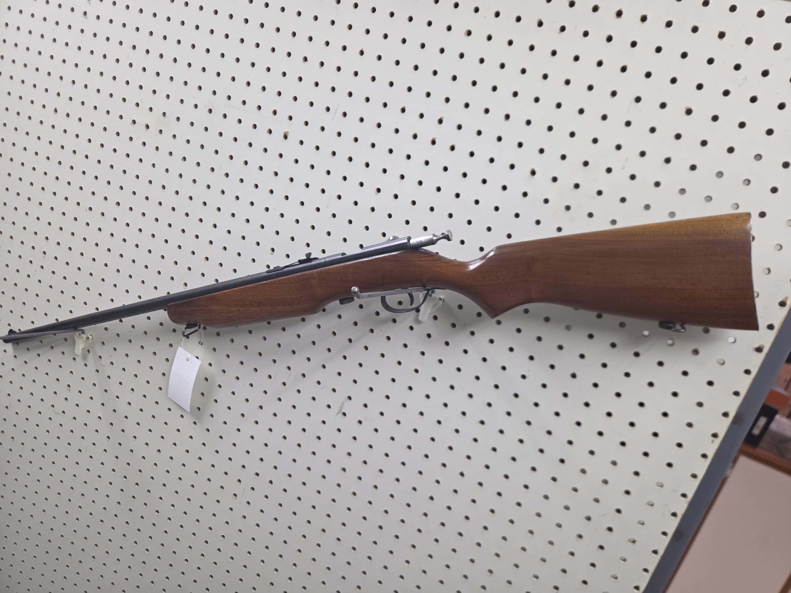 Cooey 2 Bolt-action rifle 20261018_094118 with a wood stock mounted on a pegboard wall.