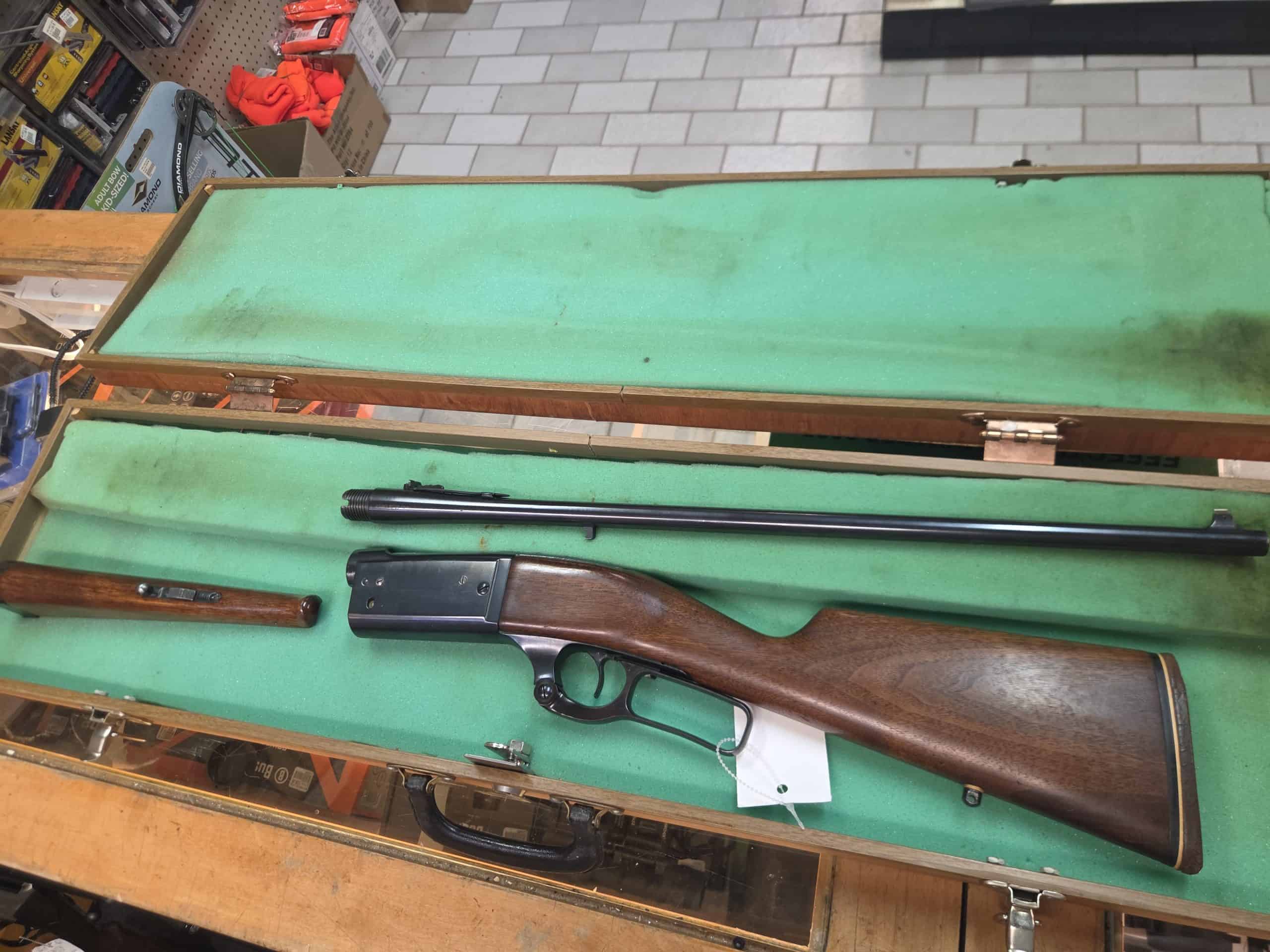 Savage 2 A disassembled 20261018_094247 lever-action rifle with a wood stock and barrel inside an open green-lined storage case.